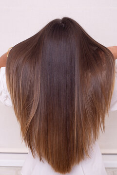 
Female back with long straight brunette hair in hairdressing salon
