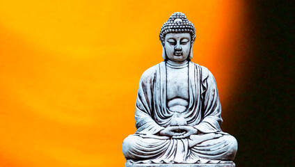 Buddha statue sitting in meditation and golden background.