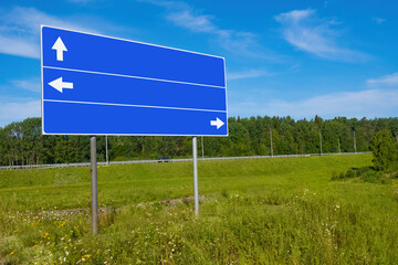 Road signs. Blue road sign without inscription. Index for names of settlements. Copy space. Blue intercity pointer on background of nature. Sign with direction arrows to settlements. Place for text