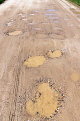 a dirt road with a lot of water holes