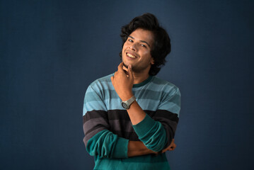 Portrait of a young man thinking on a dark background