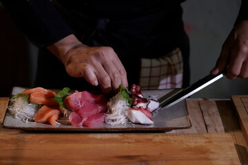 Close-up of a Japanese chef preparing to cook Japanese food. Make sushi at a traditional Japanese restaurant on a chopping board.