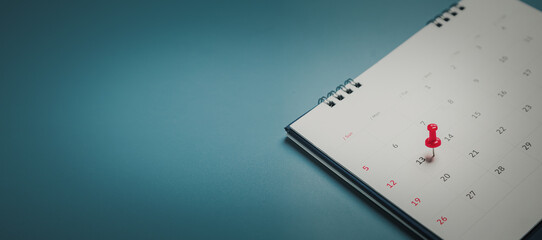 Embroidered red pins on a calendar event Planner calendar,clock to set timetable organize schedule,planning for business meeting or travel planning concept.