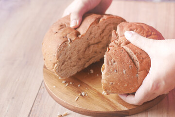 cutting baked brow bread on table.