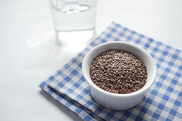 close up of flax seeds in a jar on white 