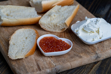 making sandwiches with baguette and cream cheese with caviar