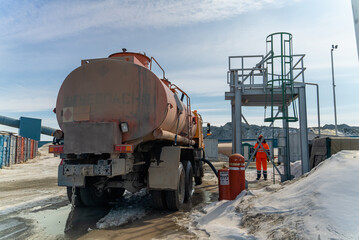 Refueling a truck carrying fuel at a gold mining site.
