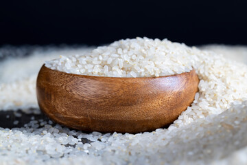 a pile of white rice on the kitchen table in a wooden plate