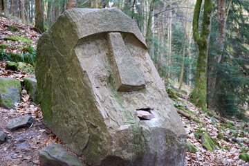 big stone head in forest