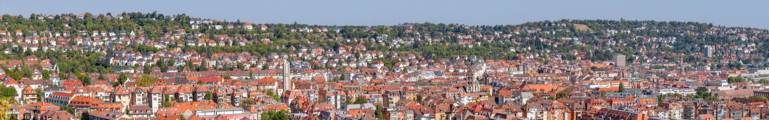 Fototapeta na wymiar Panorama of Stuttgart West, Germany, Wide view over houses, roofs, churches and buildings on a sunny summer day