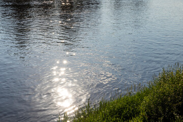 Sun glare in the water of the river with waves