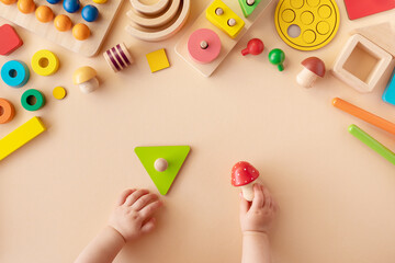 Toddler activity for motor and sensory development. Baby hands with different colorful wooden toys...