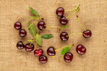Several sweet juicy cherries  on burlap, close-up, top view.
