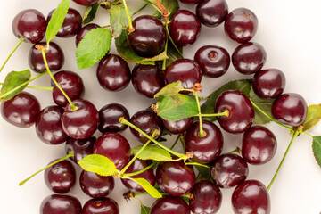 Several sweet juicy cherries on white pottery, close-up, top view.