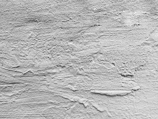 White concrete textured wall with uneven streaks. Concrete background. Concrete wall with drops of plaster