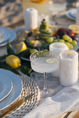 Romantic luxury picnic on the beach. Boho decoration with lemons. Bachleorette party, couple date, birthday party