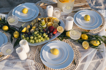 Romantic luxury picnic on the beach. Boho decoration with lemons. Bachleorette party, couple date, birthday party. 