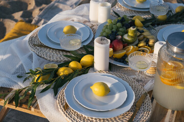 Romantic luxury picnic on the beach. Boho decoration with lemons. Bachleorette party, couple date,...