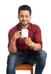 Handsome smiling man with cup of coffee or tea isolated on white background