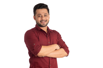 Portrait of a happy young man posing with arms crossed or hands folded on a white background