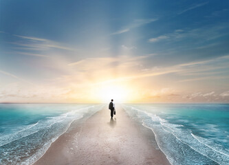 lonely business man walking sea way with a sunrise horizon