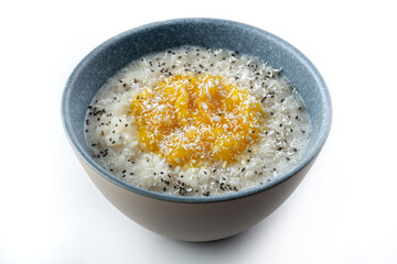Milk rice porridge with orange jam. Sprinkled with coconut. selective focus.
