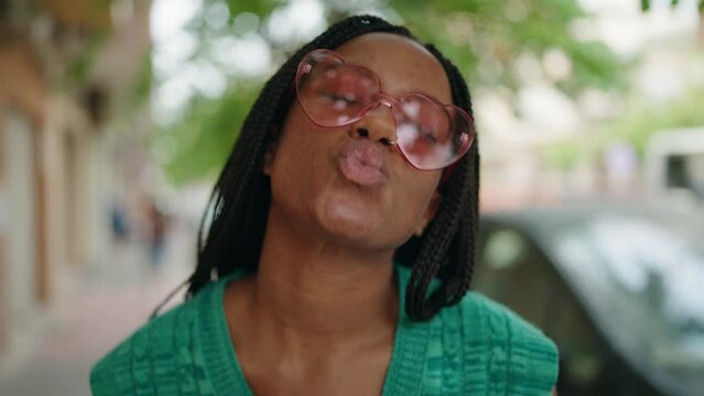 African american woman smiling confident wearing heart sunglasses at street