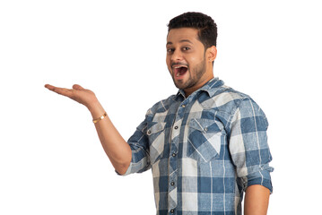 Portrait of a successful cheerful young man holding and presenting something on hand with a happy smiling face.