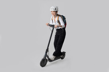 An Asian women rides an electric scooter to work.