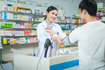 Fototapeta na wymiar Female pharmacist counseling customer about drugs usage in a modern pharmacy drugstore.