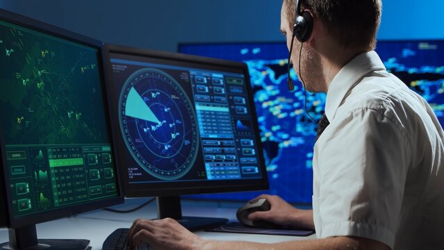 Workplace of the professional air traffic controller in the control tower. Caucasian aircraft control officer works using radar, computer navigation and digital maps. Aviation concept.