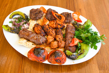 Grilled Turkish Adana, Urfa  Kebab with grilled vegetables, onion and rice on plate. Adana durum.