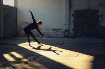 Gardinen Ballerina dancing in an abandoned building on a sunny day © Solid photos