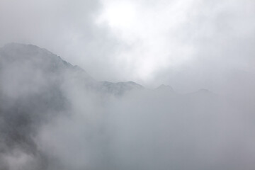 Fototapeta na wymiar Foggy mountains scenery . Clouds over mountain peaks