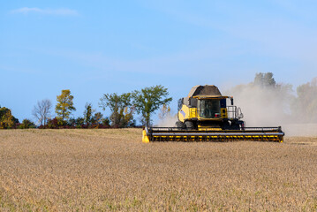 Combine harvester in action in a wheat field on a clear autumn day