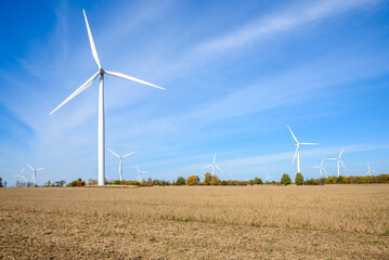 Wind farm in a rural landscape under blue sky in autumn. Copy space.