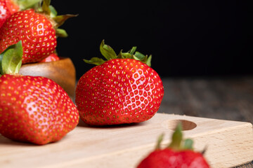 Ripe red strawberries lying on a wooden tray