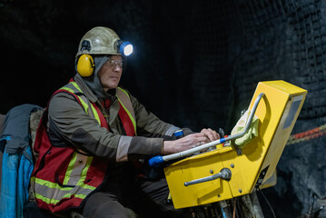 The driller works in an underground mine on a stationary drilling machine.