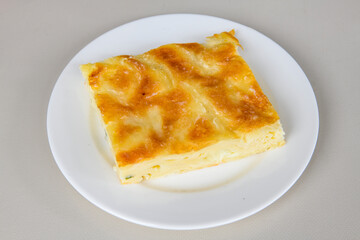 Turkish style meat stuffed filo dough borek served kol boregi. Cheese and minced pie are sliced on a marble background. Turkish name: Kol Boregi, kiymali, peynirli su boregi.