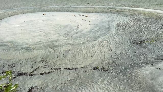 the dark sand of the Pacific Ocean, Vancouver Island, it is clear that the water went into the sea and blur after the water raged on shore, traces sand is dirty and dark Rathtrevor Beach, Parksville