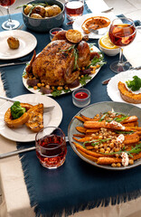 Traditional holiday dinner for celebration Thanksgiving. Baked chicken, potatoes and sides. Family party or gathering. Fall table setting. Top view table scene