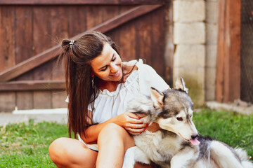  Woman and Dog.Smiling  Beautiful Woman having fun and  hugging  cute siberian Husky Dog at the...