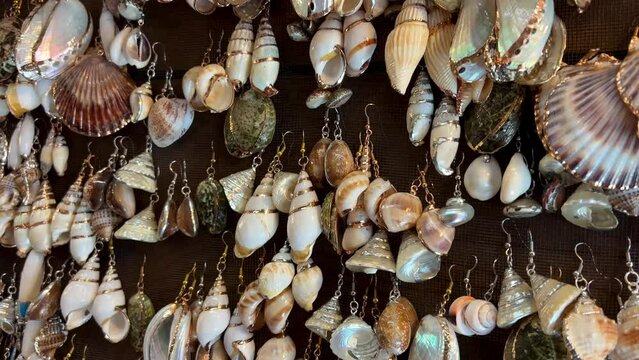 earrings and various jewelry made from real ocean shells They hang on the counter sparkling in different colors also gold trim at Ocean Vancouver Canada Goats on the roof country market in Coombs.