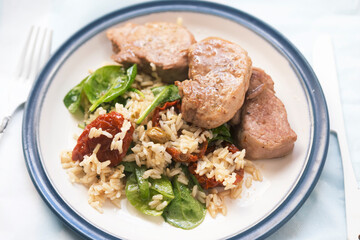 Pork loin with rice, spinach and sun dried tomatoes