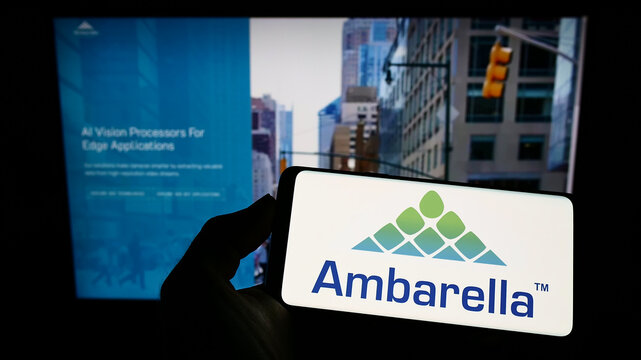 Stuttgart, Germany - 07-29-2022: Person holding smartphone with logo of US semiconductor company Ambarella Inc. on screen in front of website. Focus on phone display.