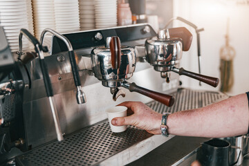 Close up view of barista hand preparing coffee espresso in automatic coffee machine in cafe