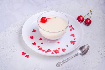 White vanilla dessert sprinkled with hearts on gray marble background for Valentine's Day
