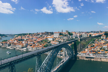 Fototapeta na wymiar View of Iron famous bridge and Duoro bay in Oporto city from top with boats navigating 