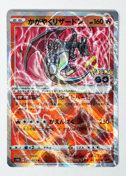 Hamburg, Germany - 30062022: photo of destroyed Japanese card Radiant Charizard from the 2022 Pokémon GO set with scratches and paint marks.
