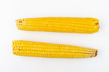 Two ripe sweet corn isolated on white background. Healthy vegan eating concept. Fresh vegetable ingredients. Organic food.